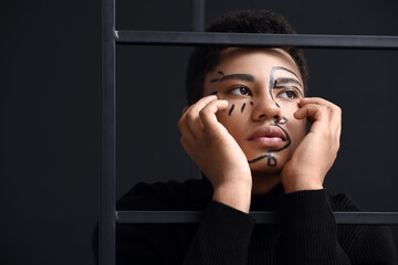 Poster - Young African-American guy with paint on face against dark background