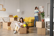 © Pixel-Shot - Young couple with cardboard boxes in their new house on moving day