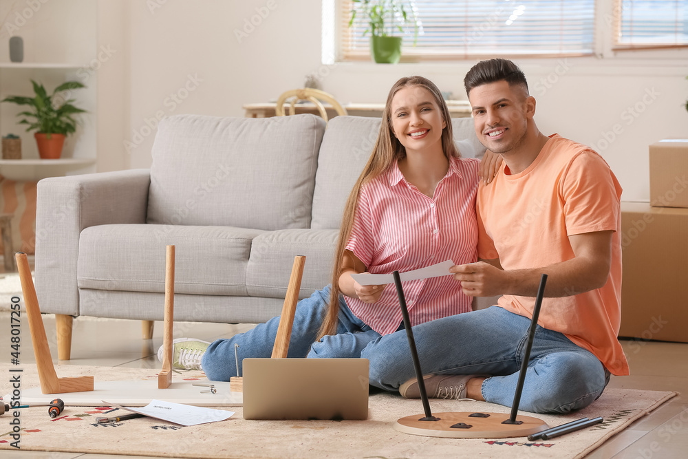 Young couple assembling furniture at home