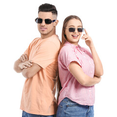 Canvas Print - Young couple wearing stylish sunglasses on white background