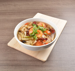 cook hot and spicy tom yum soup with mushroom and mixed vegetables in white bowl on wood background asian halal vegan menu