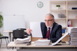 © Elnur - Aged male employee and too much work at workplace