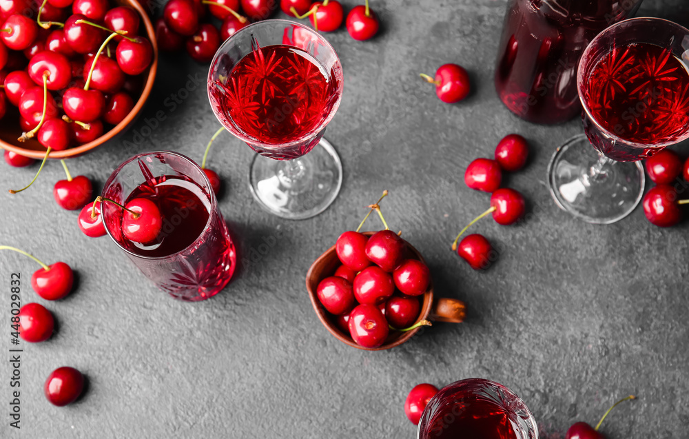 Composition with glasses of sweet cherry wine on dark background