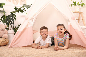 Wall Mural - Cute little children in toy wigwam at home