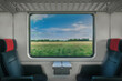 Blick aus dem Fenster eines fahrenden Zuges auf eine Landschaft
