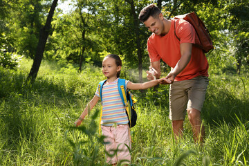 Sticker - Father spraying tick repellent on his little daughter's arm during hike in nature