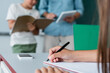 © LIGHTFIELD STUDIOS - Cropped view of schoolkid writing on notebook near smartphone in classroom