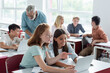 © LIGHTFIELD STUDIOS - Schoolkid pointing at laptop near teacher and multiethnic classmates