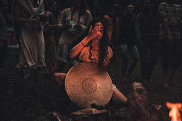 Fototapete - beautiful shamanic girl playing on shaman frame drum in the nature.