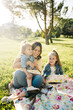 © ADDICTIVE STOCK - Mother with little daughters resting in park