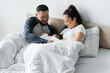 © LIGHTFIELD STUDIOS - cheerful asian parents looking at daughter in bed
