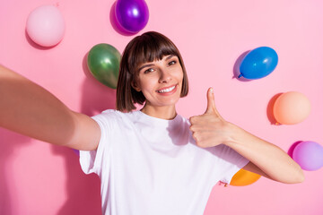 Sticker - Self-portrait of attractive trendy cheerful girl showing thumbup decor air balls flying isolated over pink pastel color background