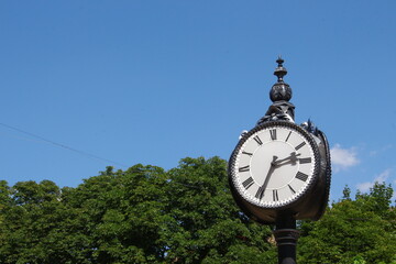 Wall Mural - Metal dial and chairs of a street clock in the park