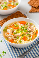 Sticker - Noodle soup. Homemade soup with chicken broth, carrots and noodles in a bowl on a gray concrete background. Delicious autumn or winter soup.