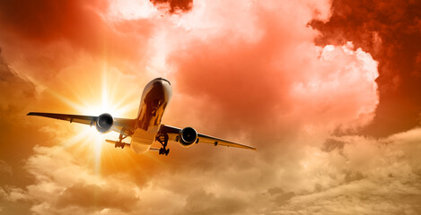 Wall Mural - plane goes on takeoff at sunset on cloudy sky background