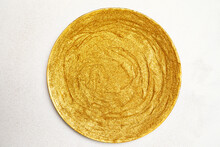 Top View Of Creative Round Plate Painted With Glittering Golden Pigment And Placed On White Table