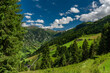 Summer valley with Grossarler Ache small river and blue cloudy sky