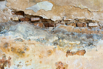 Wall Mural - Old cracked weathered plastered brick wall background texture. Dirty peeled plaster wall with falling off flakes of paint