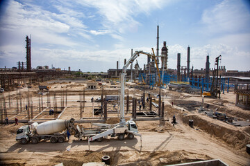 Construction of modern asphaltic bitumen plant. Making reinforcement building columns. Concrete pump truck filling forms. Mixing truck supply concrete. Aktau, Kazakhstan.