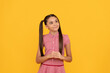 Dreamful school age girl child with pensive look fantasize about something yellow background, dreamer