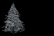  christmas tree folded of construction nails isolated on black background.