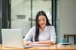 © Songsak C - Portrait of Asian businesswoman using her laptop in the office.
