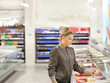 © lado2016 - Woman choosing frozen food from a supermarket freezer.