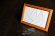 Brown photo frame with broken glass. Shards on a wooden table.