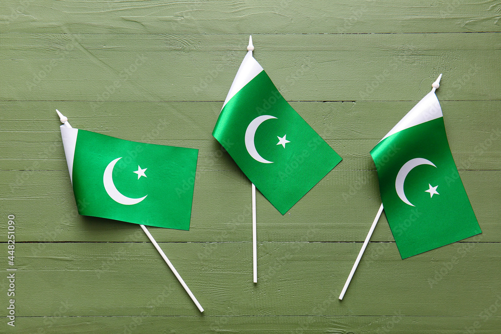 Pakistan flags on color wooden background