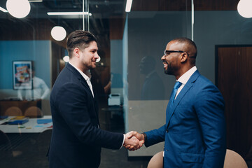 Businessman handshake success deal team at office meeting. Business people group conference discussion sit at table with boss man shaking hands and smiles