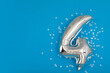 Silver balloon 4 on a blue background with confetti stars. Number four 4. Holiday Party Decoration or postcard concept with top view on blue background