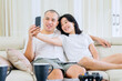 © Creativa Images - Happy couple taking selfie photo together at home