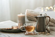 Cozy composition with a cup of tea, a teapot and candles.