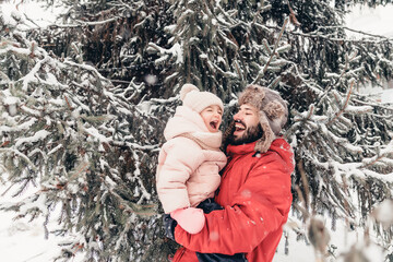 Canvas Print - Handsome bearded young dad and his little cute daughter are having fun outdoor in winter. Enjoying spending time together. Family concept