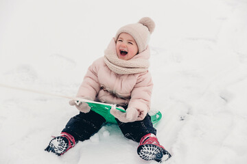 Canvas Print - Happy laughing girl wearing a pink jacket, scarf and hat, playing in a beautiful snowy winter walk. Girl enjoys winter, frosty day. Playing with snow on winter holidays. Winter holidays concept.