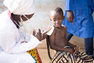 black vaccinator immunizing a small frightful african toddler against covid in a rural vaccination c