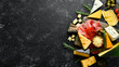 Italian appetizers. Cheese, wine, salami and prosciutto on a black stone background. Top view. Free space for your text.