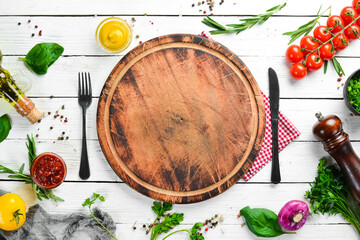 Food background. Kitchen board, vegetables, spices and kitchen utensils on the old table. Free copy space.