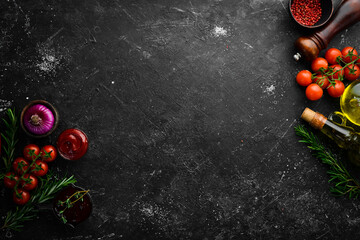 Wall Mural - Black stone cooking background. Spices and vegetables. Top view. Free space for your text.