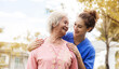 © chompoo - Happy elderly woman with a caregiver in the garden, Senior woman with nurse or doctor. Home care concept..