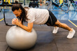 © juanpablo - young hispanic latino man in the gym slim and long-haired doing plank with a swiss ball