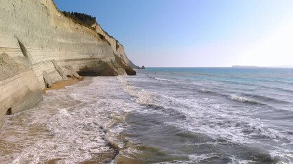 Sticker - Low flight over sea waves along rocky coast. Sunny day. Corfu, Greece.