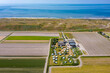 Luftaufnahme vom einem Campingplatz im Vordergrund, dahinter der Deich und die Nordsee bei Julianadorp aan Zee, Den Helder, Nordholland, Niederlande
