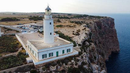 Wall Mural - Aerial view of the Far de la Mola, a lighthouse at the southeastern tip of Formentera island in the Balearic, Islands, Spain - White lighthouse at the top of a cliff in the Mediterranean Sea