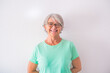 © Daniel - portrait of one pretty old and mature woman looking at the camera smiling and laughing - happy senior lady with a white background