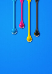 Wall Mural - cmyk ink drops on blue paper background
