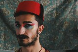 Fototapeta  - Portrait of queer young man with full face drag makeup & turkish anatolian ottoman traditional clothing with authentic patterns background *4