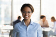 © fizkes - Head shot portrait of smiling millennial african ethnicity businesswoman in eyeglasses posing in modern office room. Confident skilled young biracial employee manager worker looking at camera.