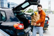© F8  \ Suport Ukraine - man putting bags with product in car trunk copy space