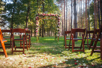 Wall Mural - wedding arch  in green forest decorated with flowers.